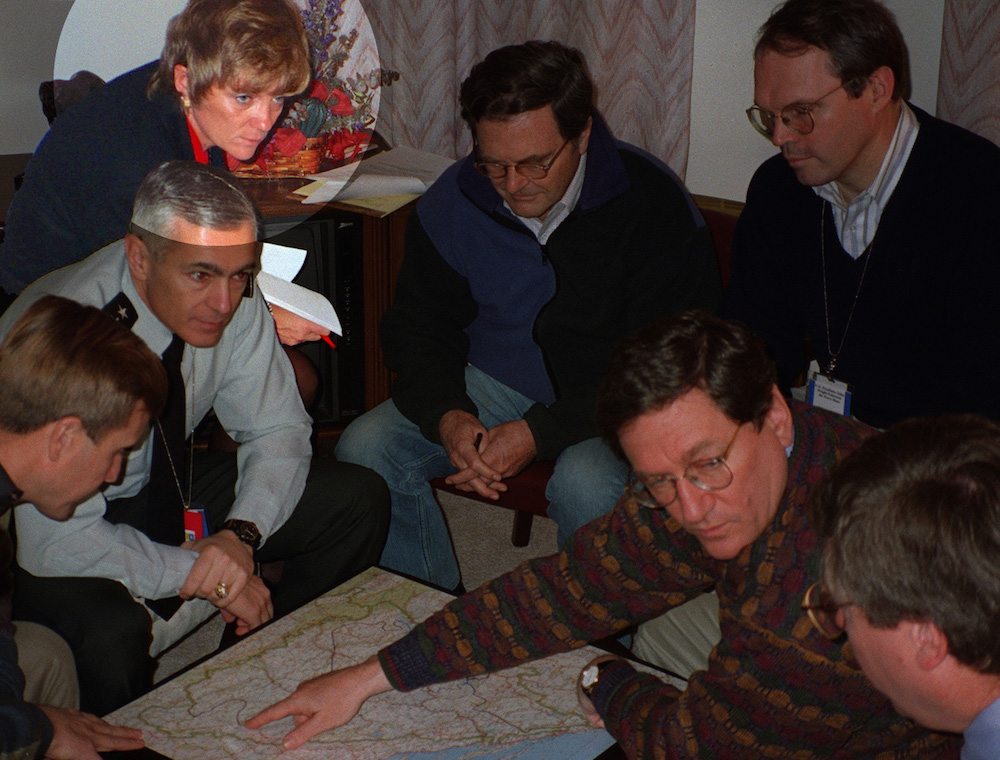 photo of the US negotiating team, huddled around Richard Holbrooke, with Rosemarie Pauli highlighted in the corner